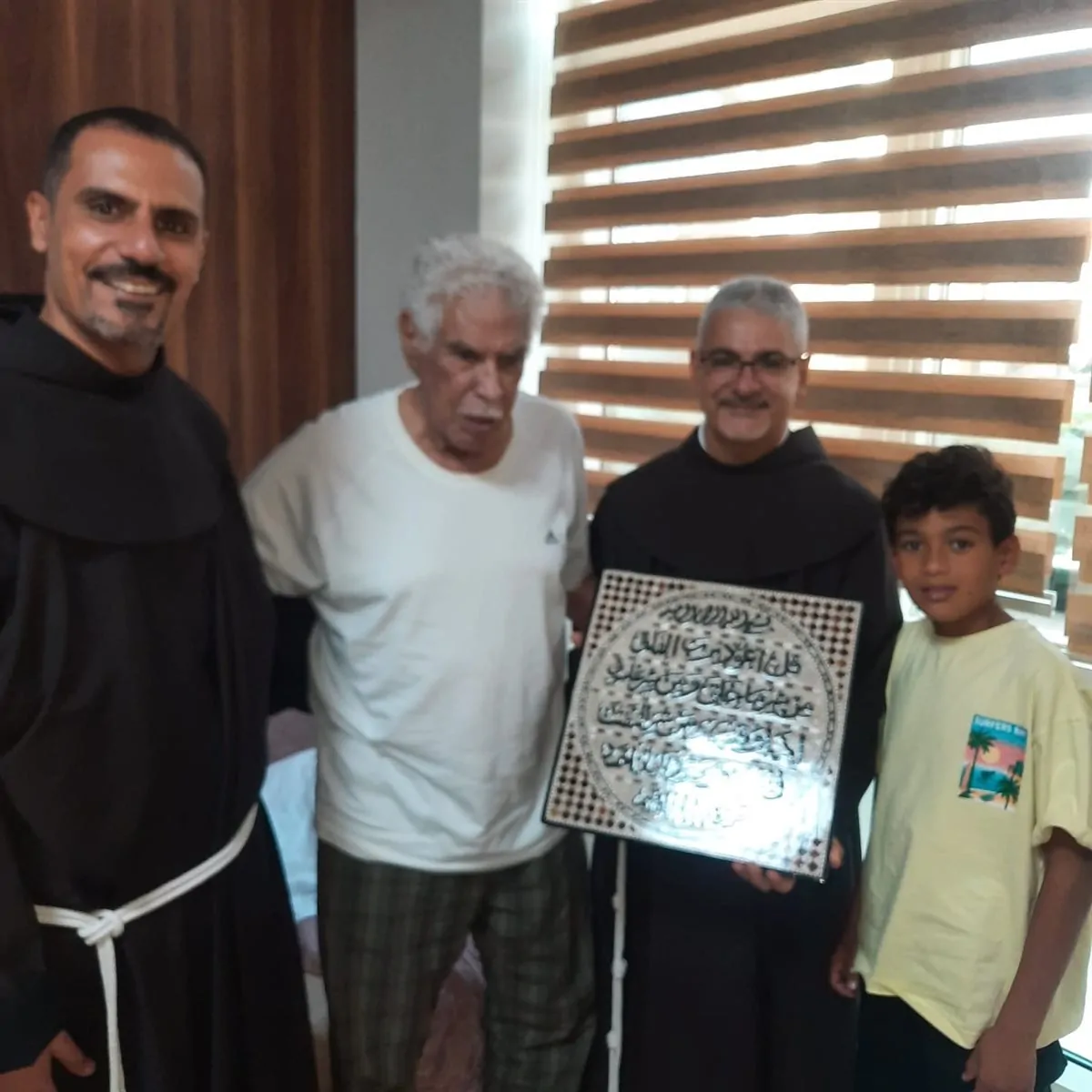 الأب بطرس دانيال والأب فيليب فرج الله يزوران الكابتن حسن شحاتة في المستشفى 4 هدية رمزية من الأب بطرس