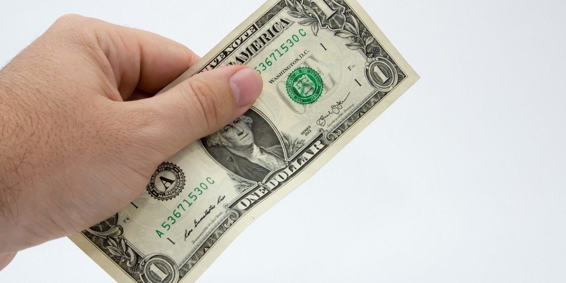 A closeup shot of a person holding a dollar bill over a white background