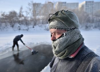 Winter swimming enthusiasts prepare an ice hole to take a swim at a lake in the Siberian city of Novosibirsk with the air temperature at around minus 35 degrees Celsius on December 9, 2023. (Photo by Vladimir NIKOLAYEV / AFP)